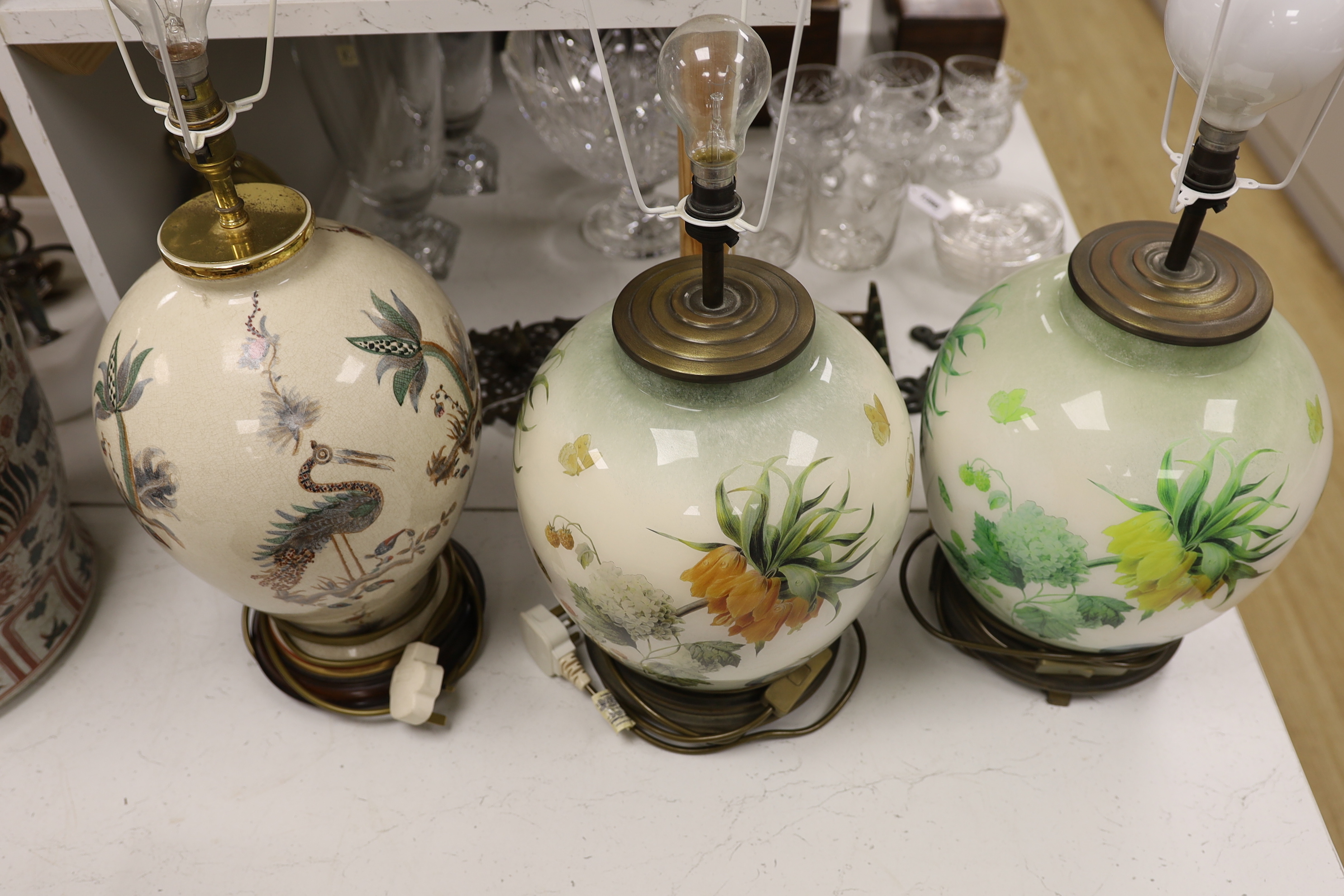 A pair of floral reverse decorated glass decorative table lamps and a similar crackle ware table lamp, 40cm not including light fitting